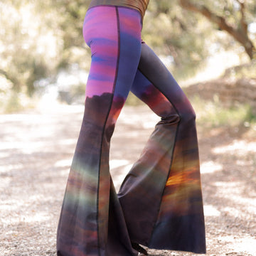 Colorful bell-bottom pants being worn outdoors on a gravel path.